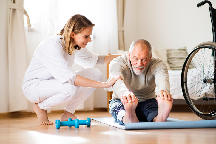 Health visitor and senior man during home visit.